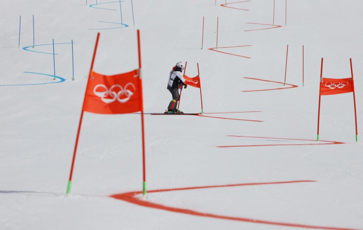 2022 Beijing Olympics - Alpine Skiing - Mixed Team Parallel 1/8 Finals - National Alpine Skiing Centre, Yanqing district, Beijing, China - February 19, 2022. An Olympic staff member on the course removes gate flags after the event was postponed due to wea