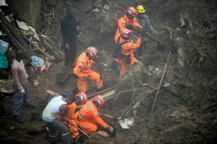 In a dense fog, rescue workers sort through the rubble and muck on February 19, 2022 as the search following landslides and flooding in Petropolis, Brazil entered its fifth day