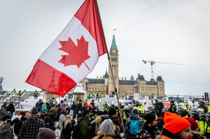 Demonstrators protest in front of Parliament Hill as police deploy to remove them on February 19, 2022, in Ottawa, Canada