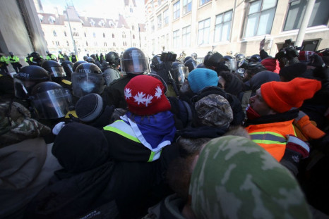 Canadian police officers face off with protestors, as they work to restore normality to the capital while trucks and demonstrators continue to occupy the downtown core for more than three weeks to protest against pandemic restrictions in Ottawa, Ontario, 
