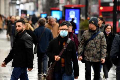 A shopper wearing a protective face mask walks on Oxford Street, as rules on wearing face coverings in some settings in England are relaxed, amid the spread of the coronavirus disease (COVID-19) pandemic, in London, Britain, January 27, 2022. 