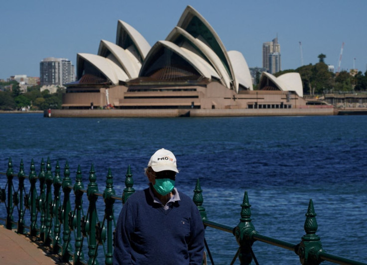A person wearing a face mask walks along the harbour waterfront across from the Sydney Opera House during a lockdown to curb the spread of coronavirus disease (COVID-19) in Sydney, Australia, October 6, 2021. 