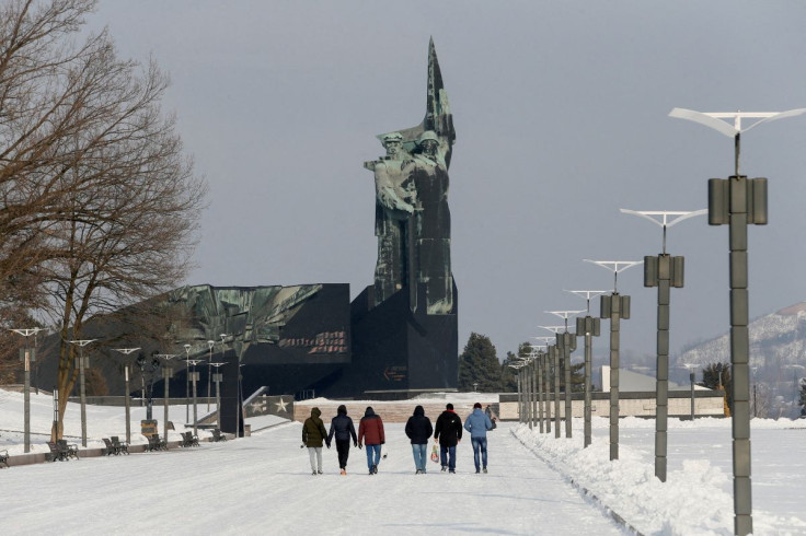 People walk towards a monument to the Liberators of Donbass in the rebel-held city of Donetsk, Ukraine January 27, 2022. 