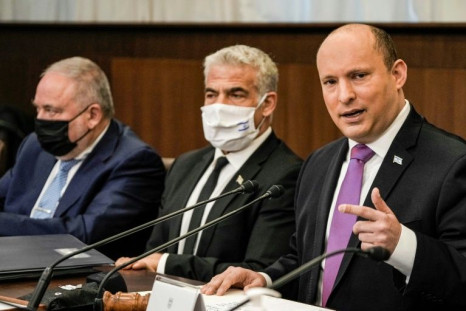 Israeli Prime Minister Naftali Bennett, on the right, chairs the weekly cabinet meeting, with Foreign Minister Yair Lapid to his left and Finance Minister Avigdor Lieberman, on February 20, 2022