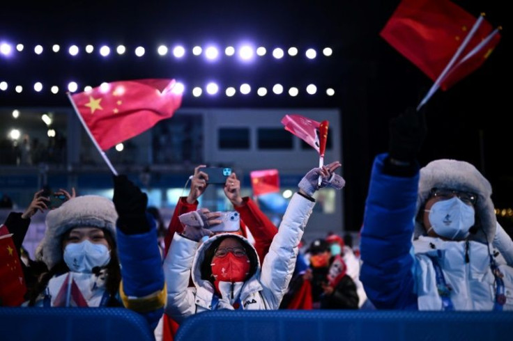 Volunteers wave flags during a victory ceremony