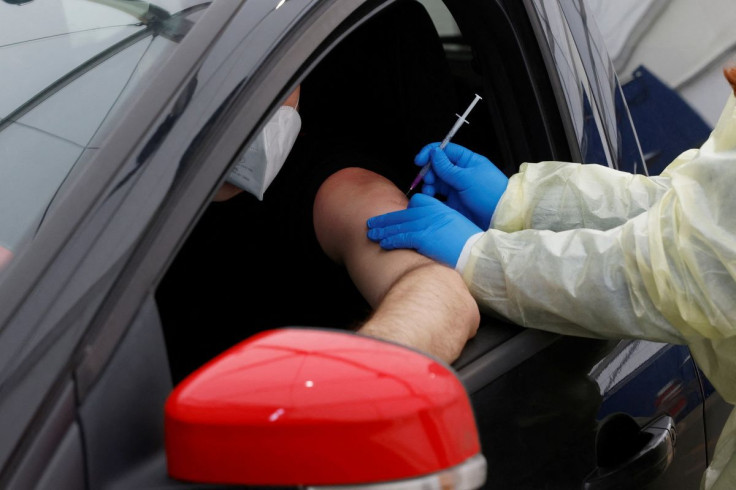 A health worker vaccinates a person with a dose of coronavirus disease (COVID-19) vaccine at the first drive-in vaccination center in Berlin, Germany, February 10, 2022.