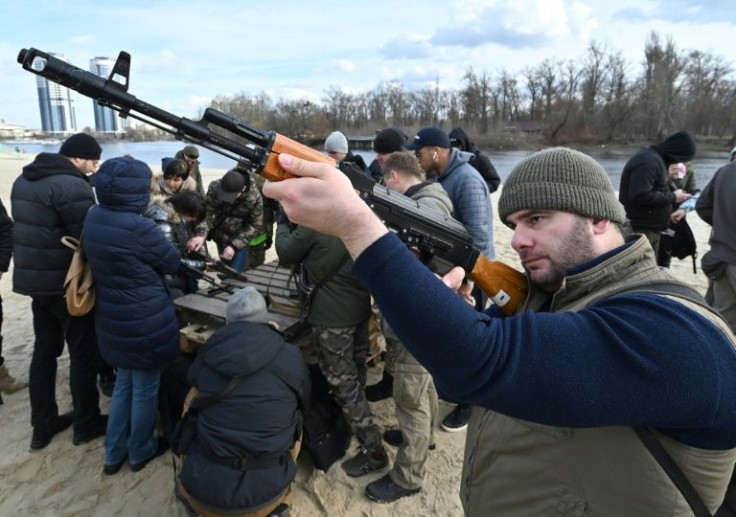 Residents attend an open training organised for civilians by war veterans and volunteers who teach basic weapons handling and first aid on one of Kiyv's city beaches on February 20, 2022, amid soaring tensions with Russia