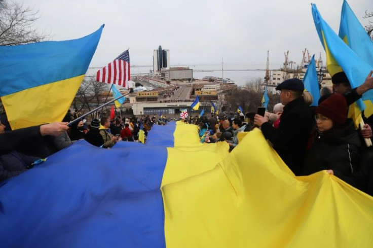 Protesters carry a giant Ukrainian flag during a rally to show unity amid soaring tensions with Russia, in the southern Ukrainian city of Odessa, on February 20, 2022