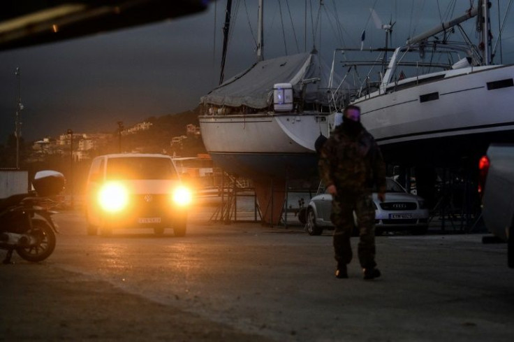 A van transfers the body of a 58-year-old Greek truck driver, the first confirmed fatality of the fire