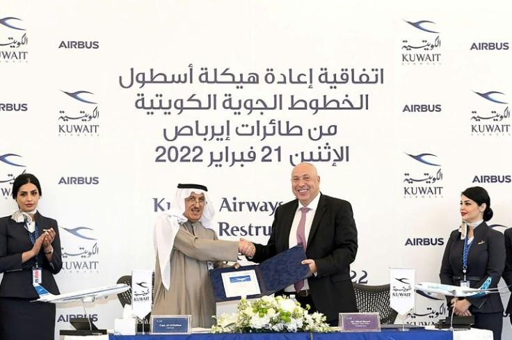 A photo provided by the Kuwaiti news agency KUNA shows the Chairman of Kuwait Airways Ali Al-Dukhan (C-L) shaking hands with Mikail Houari, President of Airbus Africa and Middle East, after signing a deal at the Kuwait Airways headquarters