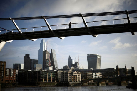 The City of London financial district is seen as people walk over Millennium Bridge in London, Britain, February 16, 2022. 