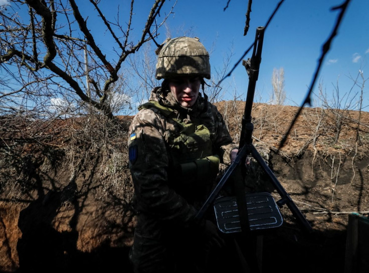 A Ukrainian service member holds a machine gun in a trench at a position on the front line near the village of Travneve in Donetsk region, Ukraine February 21, 2022. 