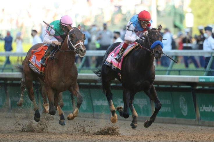 Medina Spirit, ridden by jockey John Velazquez, crosses the finish line to win the 147th running of the Kentucky Derby ahead of Mandaloun, ridden by Florent Geroux. Kentucky racing officials have stripped Medina Spirit of the victory over a positive test 