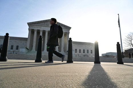 A person walks down the sidewalk near the U.S. Supreme Court building in Washington, D.C., U.S., February 16, 2022. 