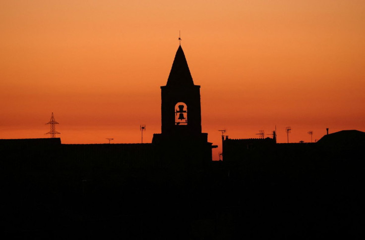 The bell tower of a church is seen during sunset in the village of Montmaneu, north of Barcelona, Spain, January 28, 2022.