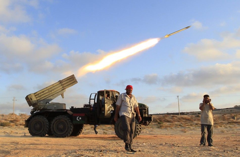Libyan rebel fighters fire a grad rocket at the front line west of the rebel-held city of Misrata
