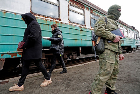 A militant of the self-proclaimed Donetsk People's Republic is seen on a platform, as evacuees board a train before leaving the separatist-controlled city of Donetsk, Ukraine February 22, 2022. 