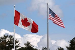 A U.S. and a Canadian flag flutter at the Canada-United States border crossing at the Thousand Islands Bridge, which remains closed to non-essential traffic to combat the spread of the coronavirus disease (COVID-19) in Lansdowne, Ontario, Canada September