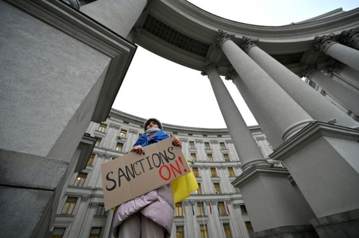 A protester supporting sanctions against Russia holds a placard during a rally outside of Ukrainian Ministry of Foreign Affair in Kyiv on February 21, 2022