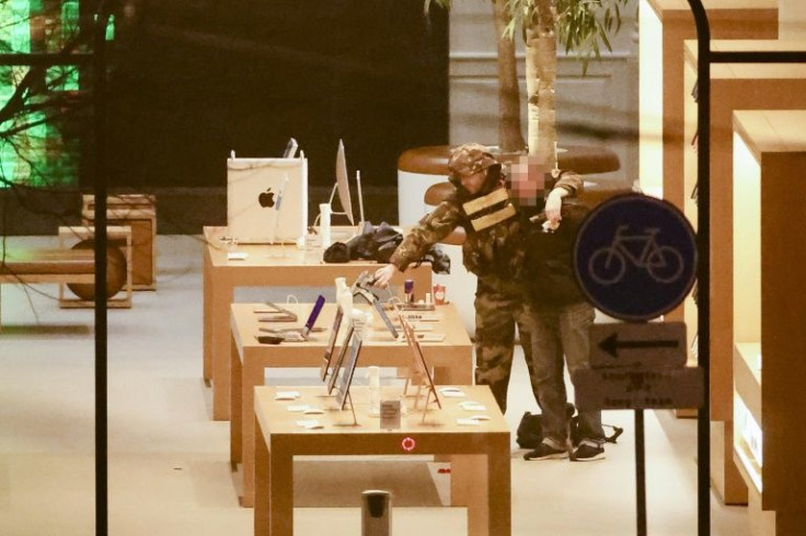 An hostage-taker puts his arm around the neck of an hostage during a robbery at the Apple Store on Leidseplein in Amsterdam
