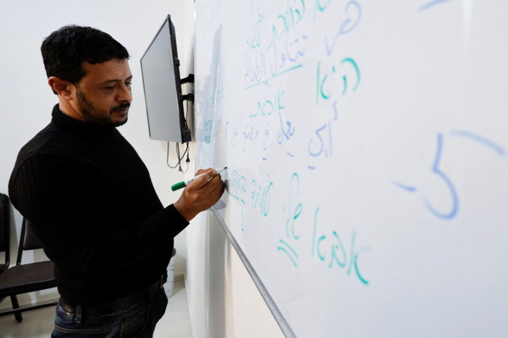 Palestinian worker Maher Al-Farra writes in Hebrew during a class at Nafha Language Center, in Khan Younis in the southern Gaza Strip February 16, 2022. 