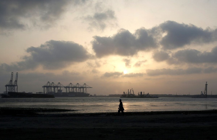 A man is silhouetted as he walks amid hot and humid weather at breakwater along port area in Karachi, Pakistan May 7, 2018. 