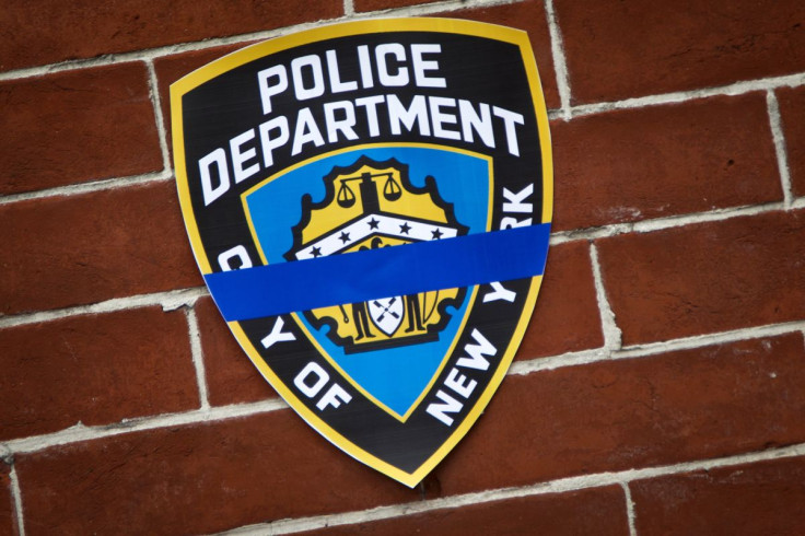An NYPD logo is pictured on wall above makeshift memorial at the site where two police officers were shot in the head in the Brooklyn borough of New York, December 22, 2014.   
