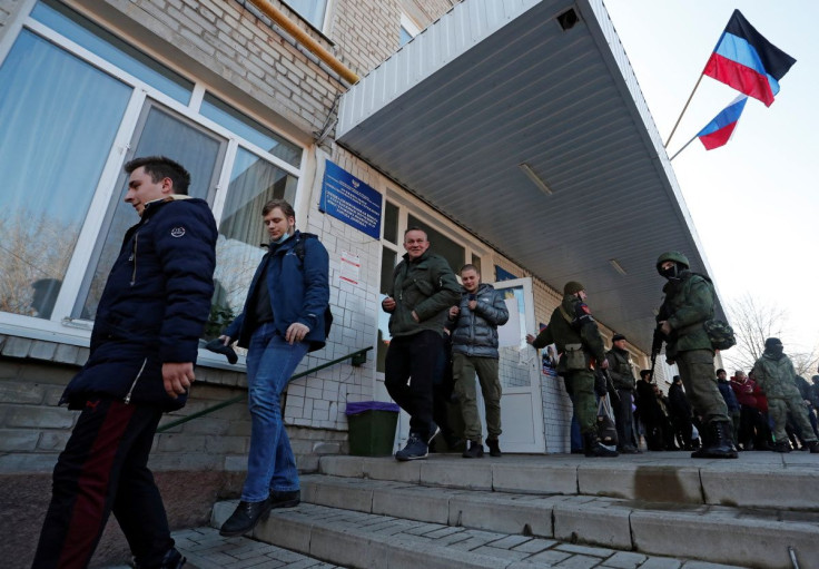Men walk out of a military mobilization point in the separatist-controlled city of Donetsk, Ukraine February 23, 2022. 