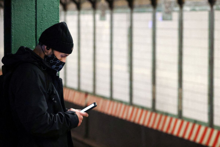 A person uses a smartphone on a subway platform in Manhattan, New York City, U.S., February 11, 2022. 