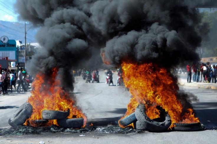 Demonstrators gather behind a burning street barricade during a wage protest in which a local journalist was killed, in Port-au-Prince, Haiti February 23, 2022.
