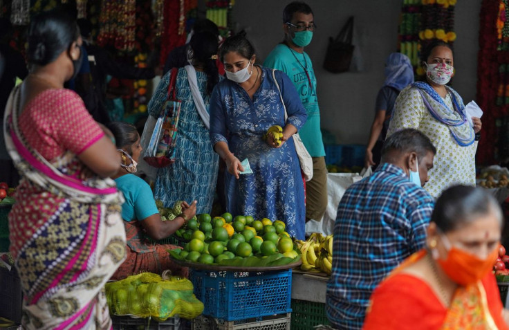 A woman wearing a protective face mask buys fruit in a market, amidst the spread of the coronavirus disease (COVID-19) in Mumbai, India, August 20, 2020.