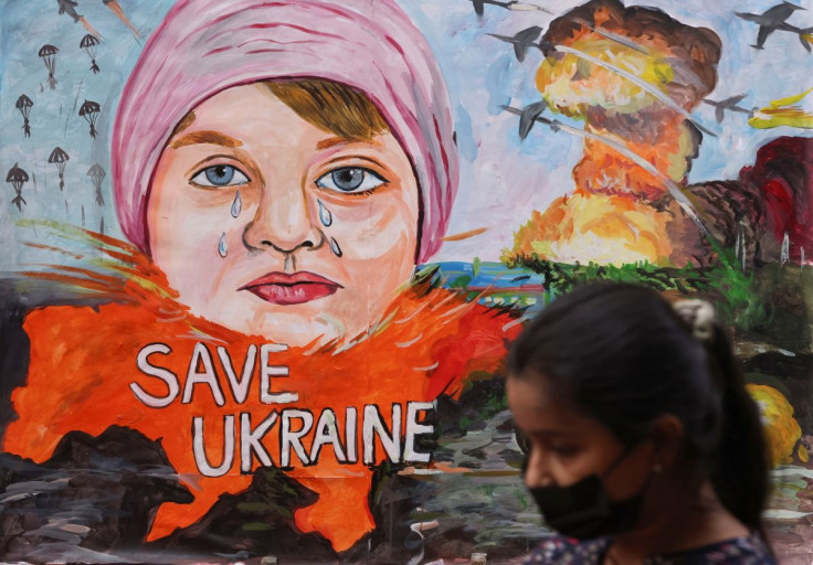 A girl walks past a painting depicting the crisis between Russia and Ukraine, outside an art school in Mumbai, India, February 24, 2022. 