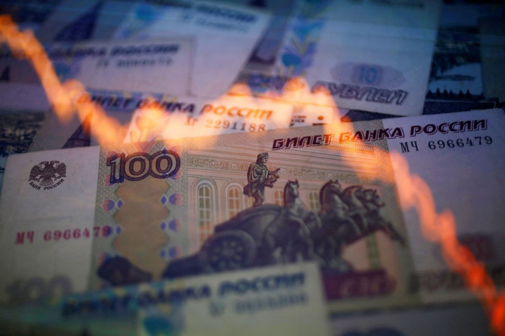 A reflection of a yearly chart of U.S. dollars and Russian roubles are seen on rouble notes in this photo illustration taken in Warsaw November 7, 2014.  