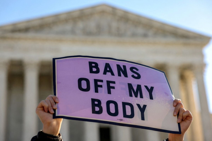 A pro-choice demonstrator holds a sign outside the United States Supreme Court as the court hears arguments over a challenge to a Texas law that bans abortion after six weeks in Washington, U.S., November 1, 2021. 
