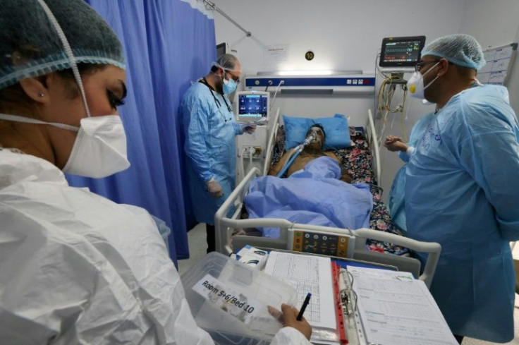 Iraqi medical workers check on a patient at the coronavirus ward of Al-Shifaa Hospital in the capital Baghdad