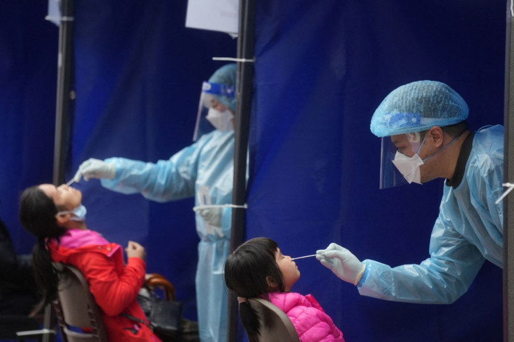 Medical workers take swab samples from residents at a community nucleic acid testing centre for the coronavirus disease (COVID-19) at Sha Tin district, in Hong Kong, China, February 7, 2022.