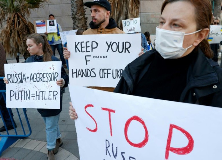 Demonstrators hold placards at the Tel Aviv protest against Russia's invasion of Ukraine on February 24, 2022