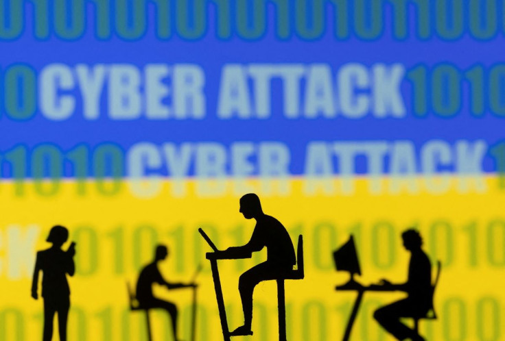 Figurines with computers and smartphones are seen in front of the words "Cyber Attack", binary codes and the Ukrainian flag, in this illustration taken February 15, 2022. 