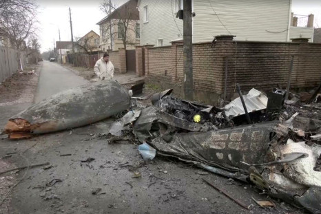 Screengrab from video shows a person inspecting the wreckage of an unidentified aircraft that crashed into a house in a residential area, after Russia launched a massive military operation against Ukraine, in Kyiv February 25, 2022. Reuters TV via REUTERS
