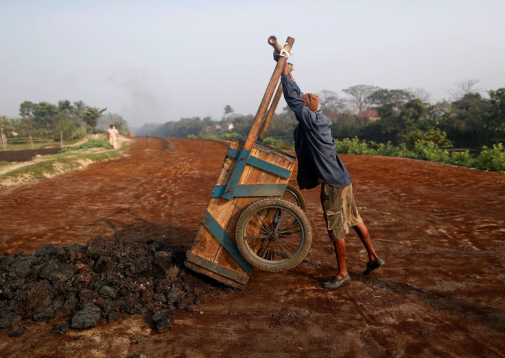 A labourer unloads fertilizer for drying at a factory which makes fertiliser ingredients out of scrap leather in Kolkata February 14, 2014.