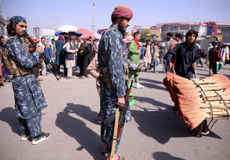 Members of Taliban security forces stand guard among crowds of people walking past in a street in Kabul, Afghanistan September 4, 2021. 
