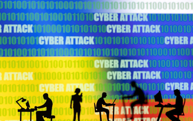 Figurines with computers and smartphones are seen in front of the words "Cyber Attack", binary codes, and Russian and Ukrainian flags, in this illustration taken February 15, 2022. 