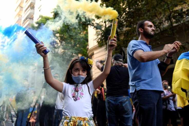 A child holds smoke bombs at a protest after Russia launched a massive military operation against Ukraine, in Buenos Aires, Argentina February 25, 2022.