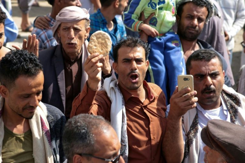 A Yemeni man holds up a piece of bread during a protest against the deteriorating economic conditions