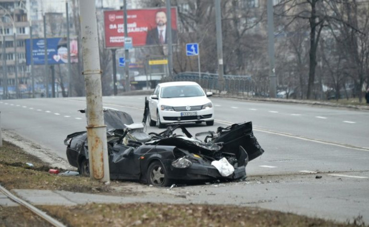 A wrecked vehicle lies on a road after a skirmish between Ukrainian and Russian forces