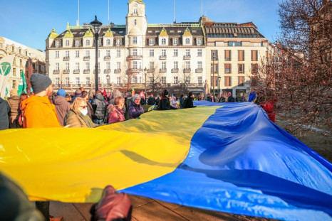 People unfold a flag of Ukraine to protest against Russia's invasion, in front of the Norwegian Parliament in Oslo, Norway, February 26, 2022. NTB/Beate Oma Dahle via REUTERSâ¨