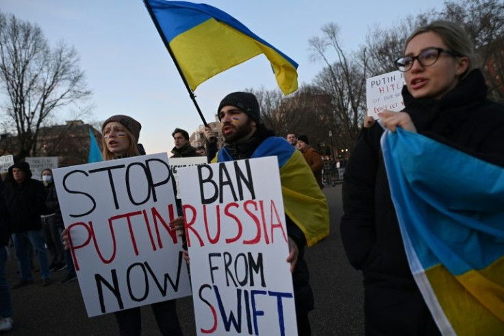 Activists protest against Russia's invasion of Ukraine and hold a sign reading "Ban Russia From SWIFT" during a rally across from the White House in Washington on February 25, 2022