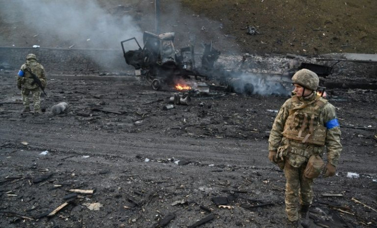 Ukrainian service members look for unexploded shells after a fight with Russian troops in the Ukrainian capital of Kyiv on February 26, 2022