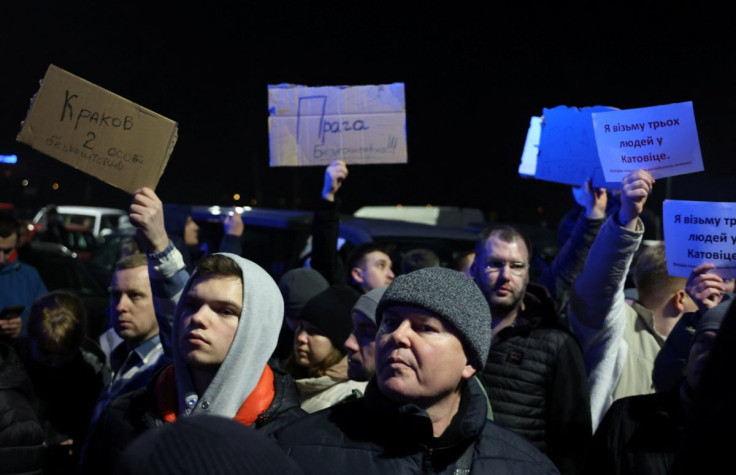 People wait in a parking lot to help refugees arriving from Ukraine with transportation and accommodation to different cities in Poland and other countries after Russia launched a massive military operation against Ukraine, in Przemysl, Poland February 26