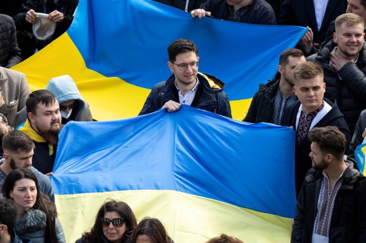A man holds a Ukrainian flag as Pope Francis leads the Angelus prayer from a window of the Apostolic Palace at Saint Peter's Square, at the Vatican, February 27, 2022. Vatican Media/ÂHandout via REUTERS